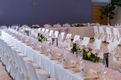 Eine in weiß und violett gedeckte Festtafel im Kongresssaal des Schloss Seggau