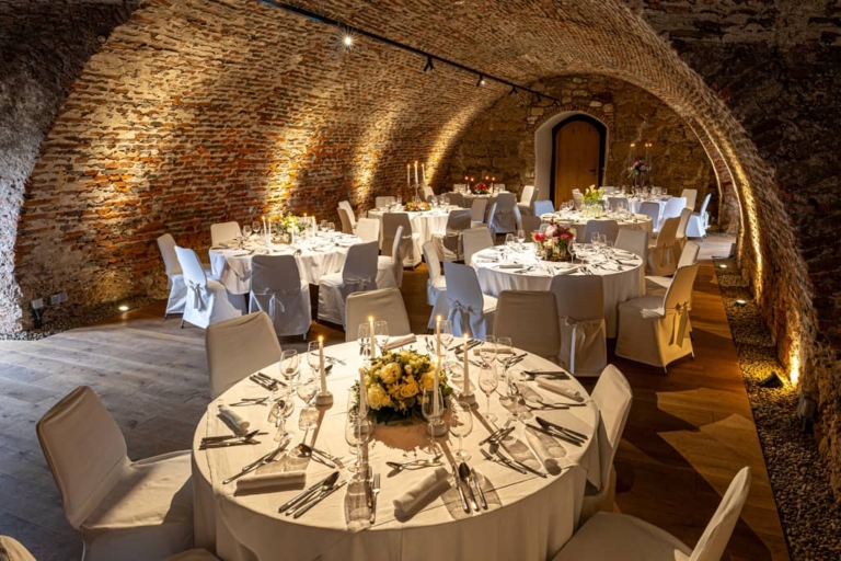 Festive round tables in the cellar vault in the upper castle of Seggau Castle