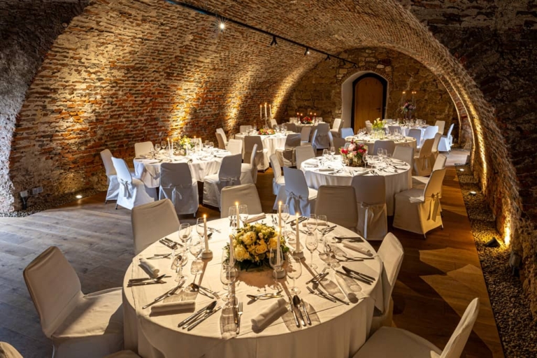 Festive round tables in the cellar vault in the upper castle of Seggau Palace