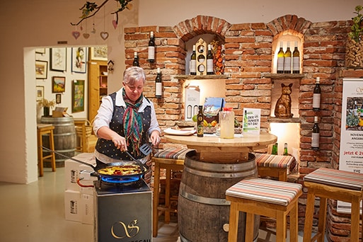 Elfi prepares a Schmölzi on a gas cooker in the wine cellar shop